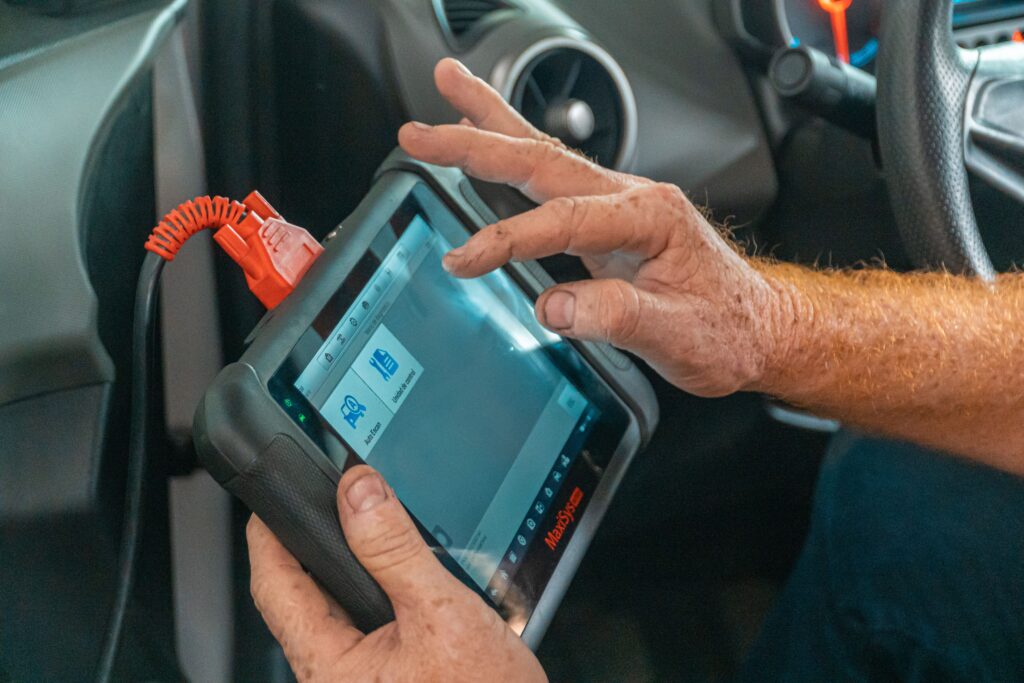 Mecanico con escaner de diagnostico en motor de coche