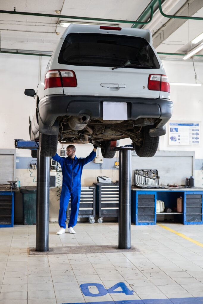 Mecanico bajo coche elevado